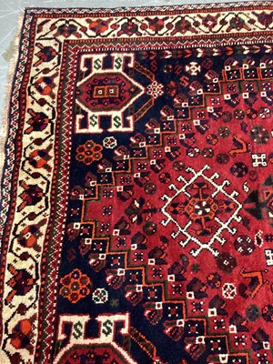 Lot 1142 - Eastern rug with geometric decoration and central medallion on red, blue and cream ground, 250cm x 161cm