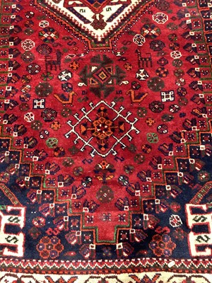 Lot 1142 - Eastern rug with geometric decoration and central medallion on red, blue and cream ground, 250cm x 161cm