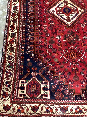 Lot 1142 - Eastern rug with geometric decoration and central medallion on red, blue and cream ground, 250cm x 161cm