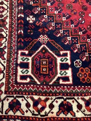 Lot 1142 - Eastern rug with geometric decoration and central medallion on red, blue and cream ground, 250cm x 161cm