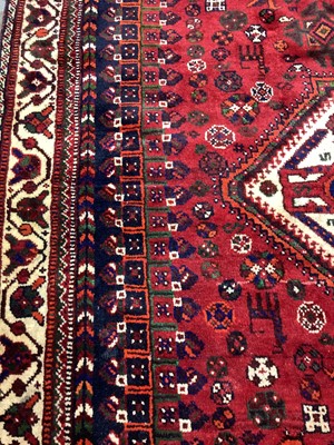 Lot 1142 - Eastern rug with geometric decoration and central medallion on red, blue and cream ground, 250cm x 161cm