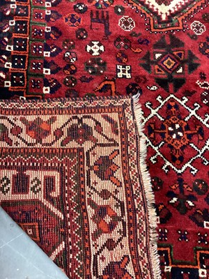 Lot 1142 - Eastern rug with geometric decoration and central medallion on red, blue and cream ground, 250cm x 161cm