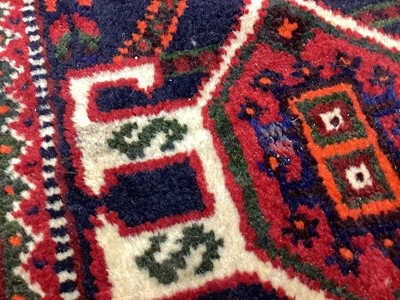 Lot 1142 - Eastern rug with geometric decoration and central medallion on red, blue and cream ground, 250cm x 161cm