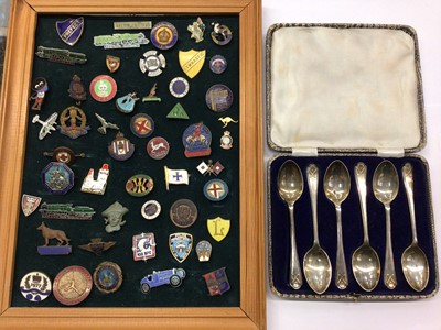 Lot 856 - Set of six silver golfing spoons in fitted case and a collection of enamelled badges mounted on a framed board