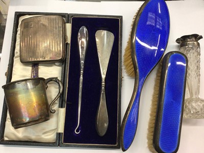 Lot 889 - Two silver and blue enamel brushes, silver cigarette case, silver mug, silver topped glass vase and silver handled button hook/shoe horn cased set