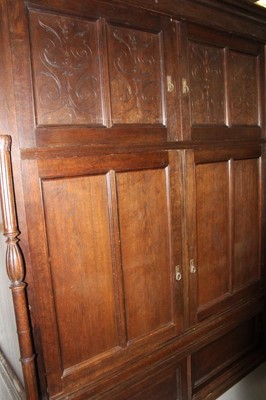 Lot 1015 - Late 19th / early 20th century Continental carved oak cupboard, enclosed by two pairs of panelled doors flanked by turned columns, with sliding doors to the plinth base, 191cm wide x 74cm deep x 24...