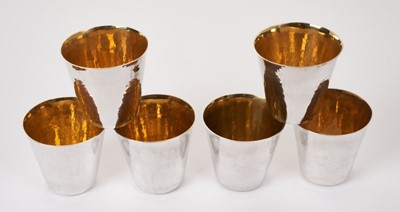 Lot 327 - Set of six contemporary silver spot hammered beakers with gilded interiors