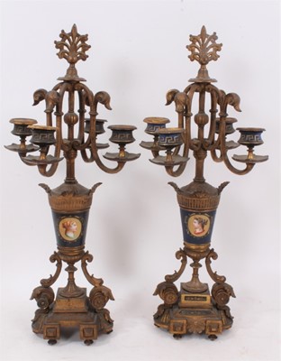 Lot 85 - Pair of 19th century Continental gilt metal and painted porcelain four branch candlesticks, with scrolling candle arms and portrait painted vase columns on stepped plinth bases, 50cm high