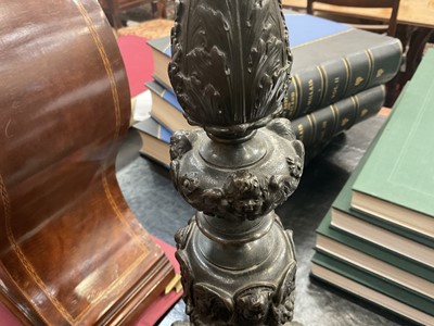 Lot 1453 - Pair of 19th century bronze candlesticks converted for electricity, each with inverted cut glass bowls, raised on flared column with mask swag and stiff leaf ornament, 71cm