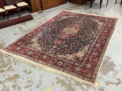 Lot 1505 - Kashan pattern carpet, with central radiating medallion and scrolling foliate arabesque on midnight blue ground, in main lotus border with tassel ends, 370 x 280cm