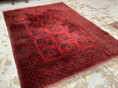 Lot 1507 - Large Bokhara rug, having three rows of five quartered medallions on claret ground, in geometric borders with tassel ends, 340 x 240cm