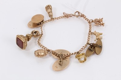 Lot 522 - 9ct gold charm bracelet with various 9ct gold charms including a yellow metal seal fob and a gold plated cufflink