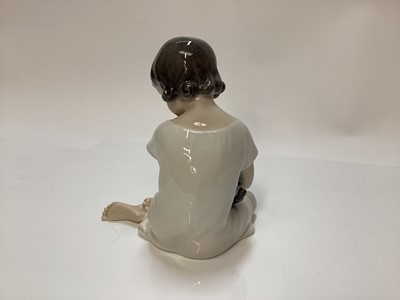 Lot 1116 - Three Royal Copenhagen porcelain figures - boy on marrow number 4539, girl with doll number 1938 and baby number 1517