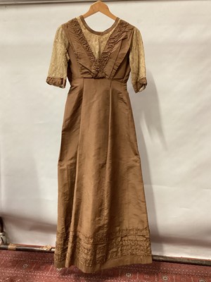 Lot 2053 - Edwardian ladies outfit in brown taffeta silk.  High waist dress with ruffled and pleated trims, flat buttoned panel to back, embroidered lace sleeves and neckline.  Plus matching long boned, fitte...