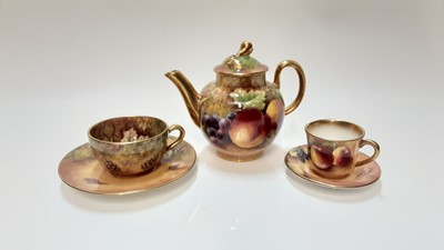 Lot 1144 - Miniature Royal Worcester teapot with hand painted fruit study signed J. Sherratt, together with matching cup and saucer,  and another cup and saucer signed T. Nutt
