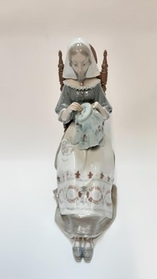 Lot 1184 - Lladro porcelain figure of a lady in a chair doing embroidery, 29cm high