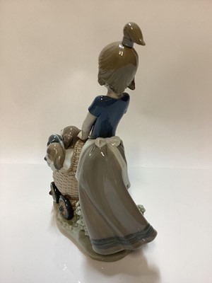 Lot 1185 - Three Lladro porcelain figure groups - girl with pram full of puppies 5364, girl with dog 5688 and girl on tricycle with kitten 5679
