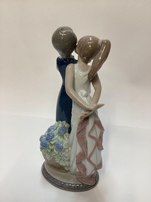 Lot 1187 - Four Lladro porcelain figures - clown with violin 5472, young couple 5555, boy and girl trying on shoes 5361 and girl with basket of puppies