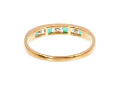 Lot 435 - Emerald and diamond eternity ring with three brilliant cut diamonds interspaced by four round mixed cut emeralds in 18ct yellow gold channel setting.