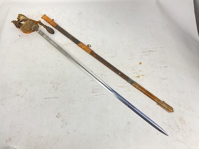 Lot 809 - George V Naval Officer's sword retailed by Gieves with regulation Gothic hilt with lions head pommel, etched blade in brass mounted leather scabbard with knot