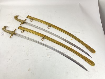 Lot 813 - Pair Regency military musicians' swords with cast leopard head and shell hilts, plain curved blades in brass scabbards (both stuck in their scabbards due to dents)