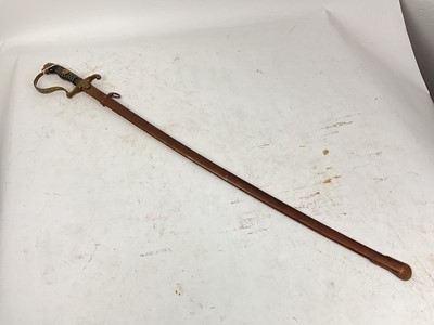 Lot 823 - Nazi Cavalry Officer's sword with brass lions head pommel and glass eyes, stirrup hilt with eagle and swastika langet, plain fullered blade in scabbard