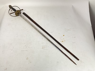 Lot 832 - 19th century Spanish rapier with brass hilt, turned ebony grip and etched tapered blade decorated with trophies and indistintly named in leather sheath and another theatrical rapier in sheath (2)