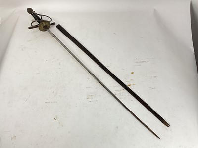 Lot 832 - 19th century Spanish rapier with brass hilt, turned ebony grip and etched tapered blade decorated with trophies and indistintly named in leather sheath and another theatrical rapier in sheath (2)