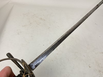 Lot 832 - 19th century Spanish rapier with brass hilt, turned ebony grip and etched tapered blade decorated with trophies and indistintly named in leather sheath and another theatrical rapier in sheath (2)