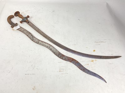 Lot 838 - 19th century Indian Tulwar with steel hilt and curved blade and old Indian dagger with waved blade decorated with figures and flowers (2)