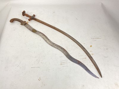 Lot 838 - 19th century Indian Tulwar with steel hilt and curved blade and old Indian dagger with waved blade decorated with figures and flowers (2)