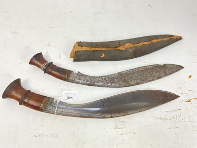 Lot 895 - Gurkha Kukri with two piece wooden grip and curved steel blade with stamped script in leather covered sheath, blade 33cm, together with another similar Kukri with no sheath, blade 34.5cm in length...