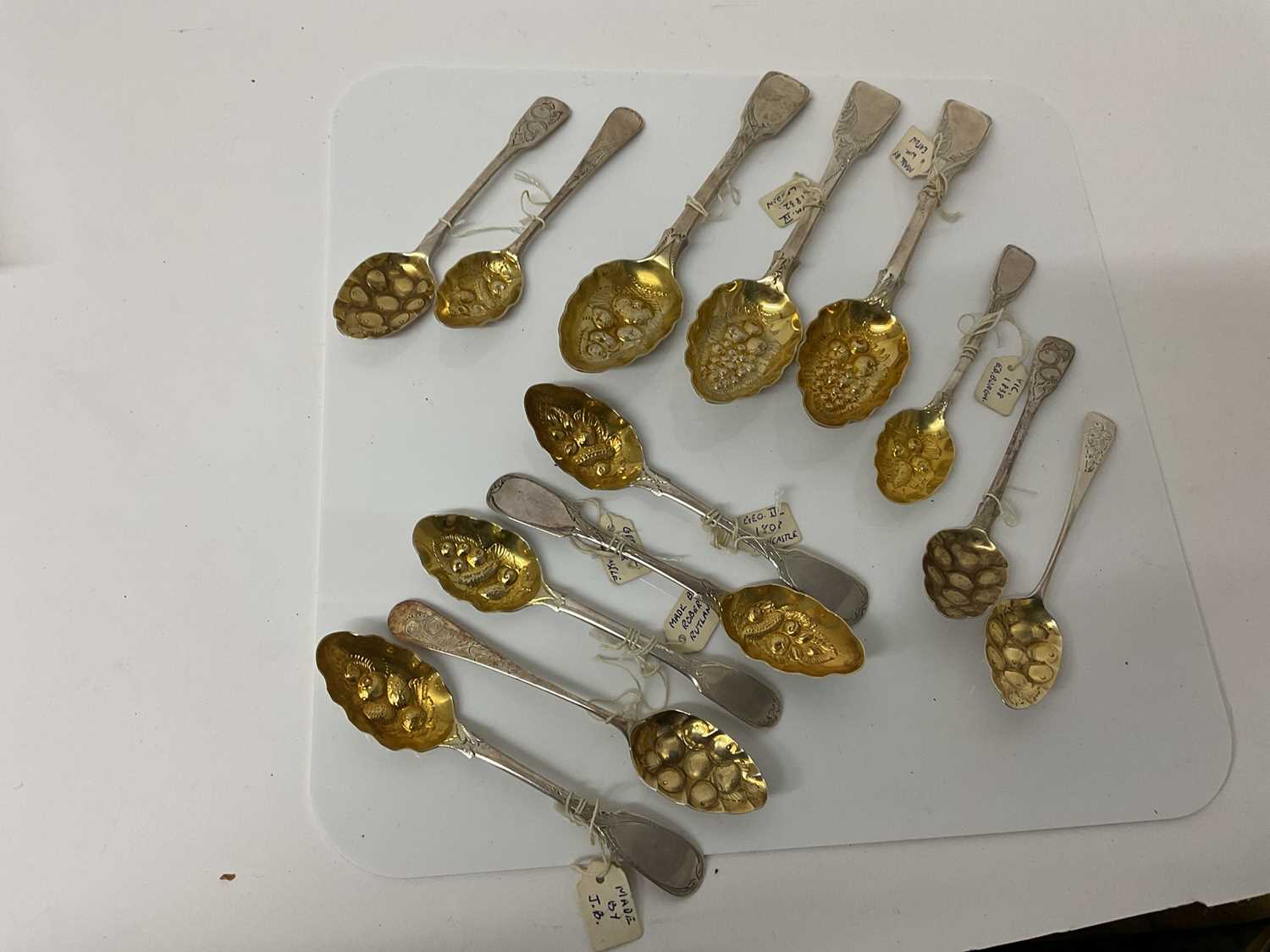 Lot 50 - Group of ten Georgian and later silver tea and desert spoons with later chased and embossed 'Berry spoon' decoration, (various dates and makers)