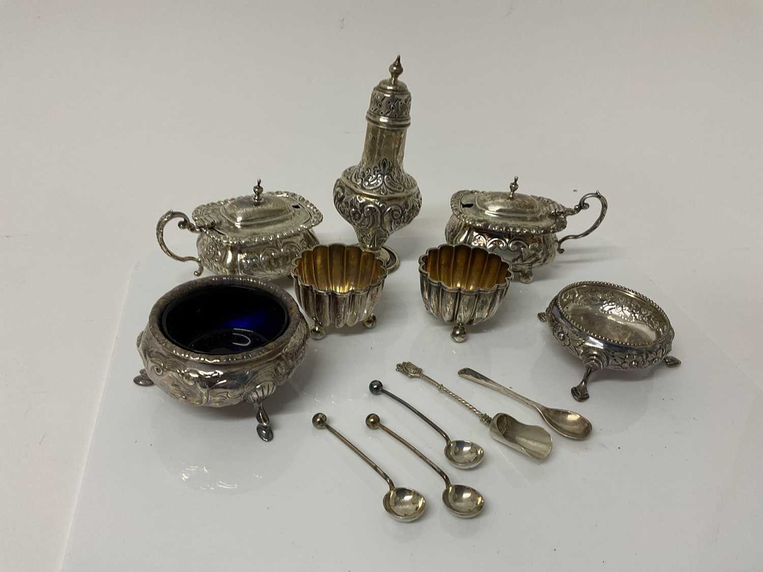 Lot 54 - Pair of Edwardian silver mustard pots with blue glass liners (Birmingham 1905 / 1907), together with an Edwardian silver Pepperette (Birmingham 1908), four silver salt cellars.