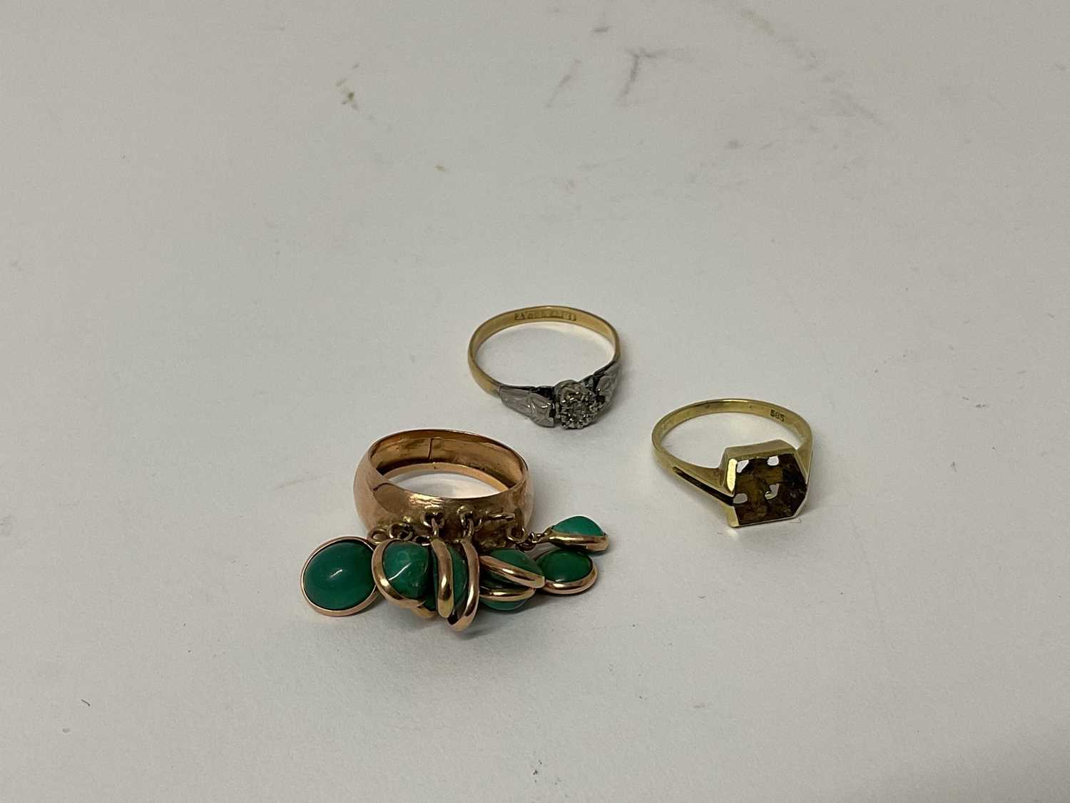 Lot 87 - 18ct gold and platinum diamond single stone ring, ring size P 1/2, 14ct gold ring, marked 585, ring size M and a yellow metal dress ring set with green stones, ring size L 1/2 (3)