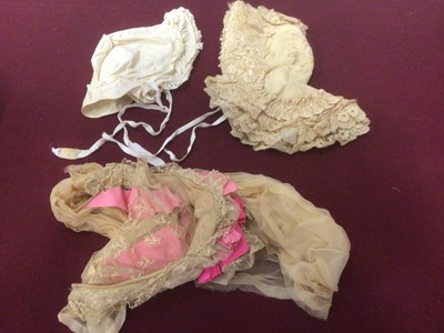 Lot 2075 - Four Victorian baby bonnets including a lace and pink ribbond half hat, an embroidered wool, satin ribbon and ruffled lace bonnet, embroidered silk cap and swan down trim and a cotton bonnet.