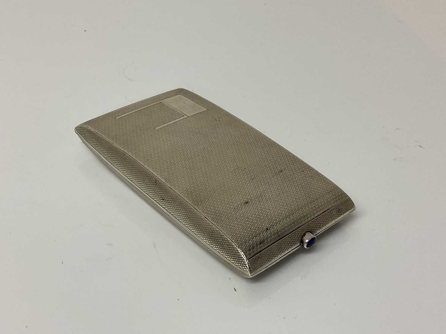 Lot 21 - George V silver cigarette case of rectangular form with engine turned decoration, gem set button and gilded interior, (Birmingham 1933), maker W T Toghill & Co, 9.3cm in overall length, all at 2.1o...