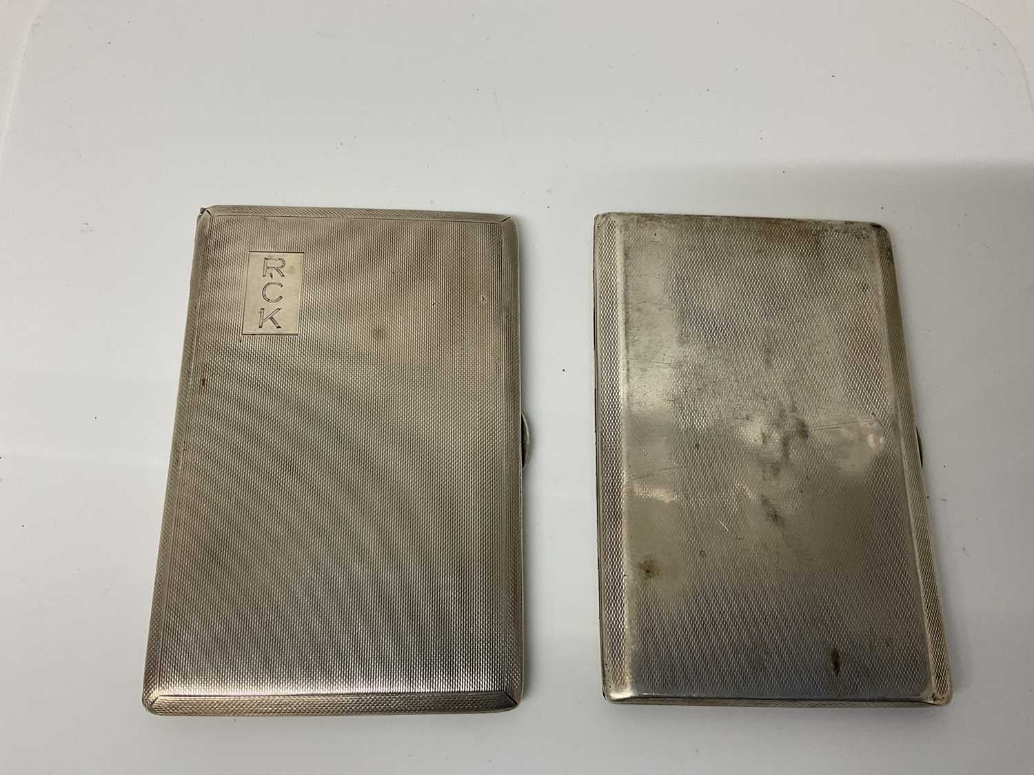 Lot 23 - George VI silver cigarette case of rectangular form with engine turned decoration and gilded interior, (Chester 1941), maker Cohen & Charles, 12.7cm in overall length, together with another similar...