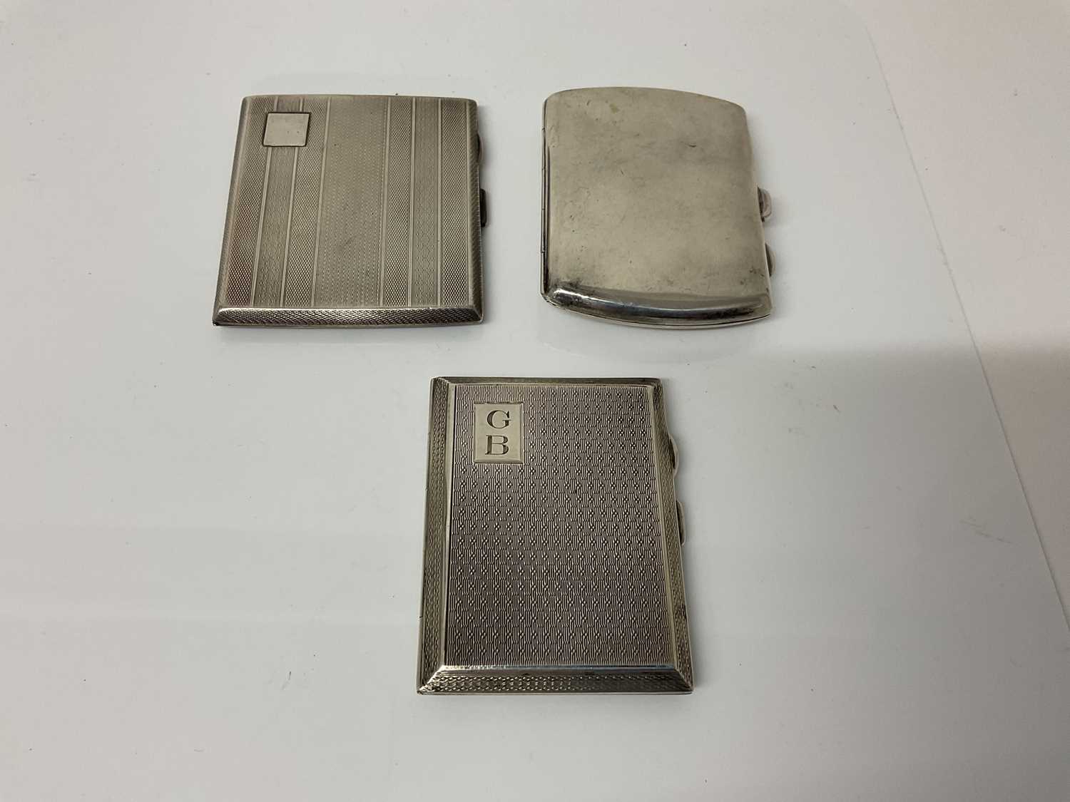 Lot 31 - George V silver cigarette case of rectangular form with engine turned decoration, (Chester 1911), maker E J Trevitt & Sons Ltd, 8cm in overall length, together with two another similar silver cigar...