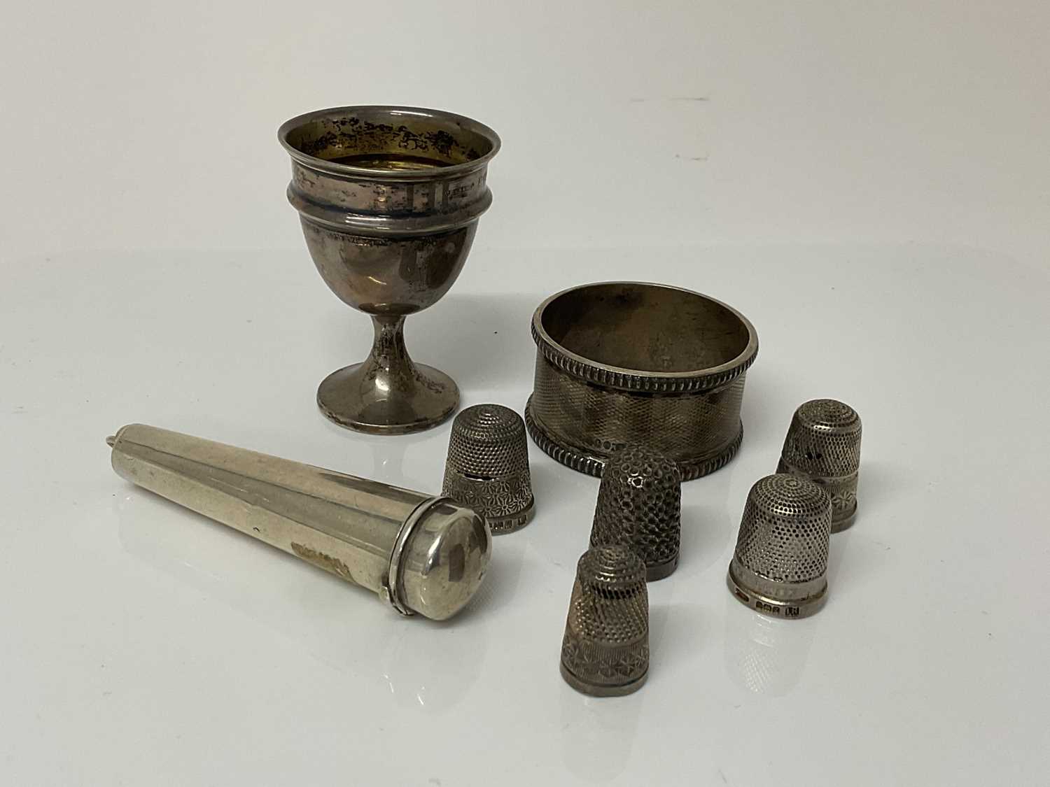 Lot 39 - Small group of Victorian and later silver items to include a cheroot holder, (Birmingham 1899), a silver egg cup (Birmingham 1939), silver napkin ring (Birmingham 1936) and five silver thimbles (va...