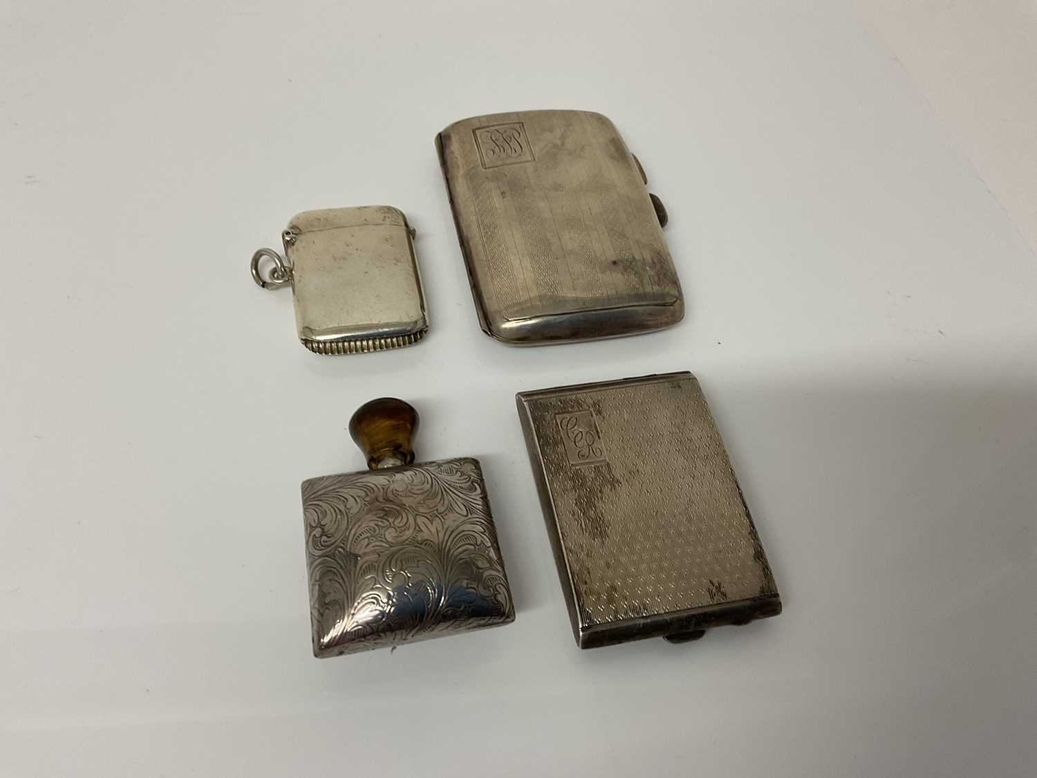 Lot 42 - George silver cigarette case with engine turned decoration, (Birmingham 1924), together with a silver match book holder, (Birmingham 1927), a silver Vesta case (Birmingham 1912) and a white metal s...