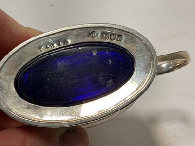Lot 124 - Edwardian silver mustard pot of oval form, with pierced decoration and blue glass liner, (London 1906), 9.5cm in length.