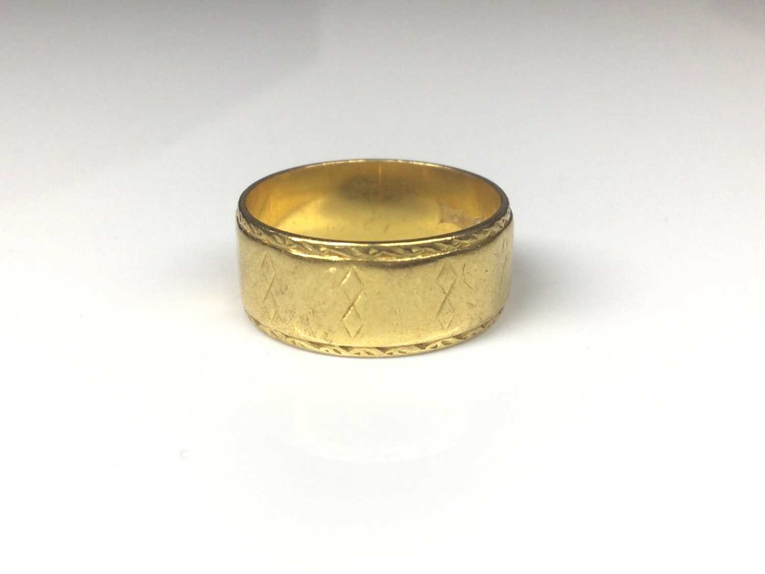 Lot 135 - 22ct gold wide band wedding ring with engraved geometric decoration