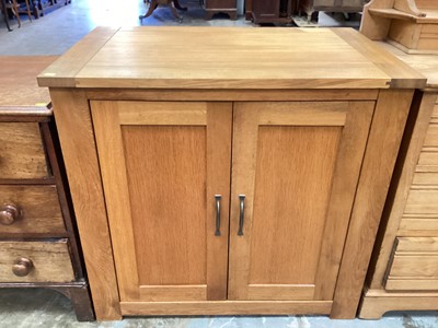 Lot 1033 - Contemporary light oak cupboard with shelved interior enclosed by a pair of panelled doors.