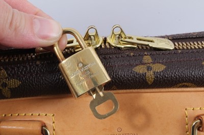 Lot 2090 - Louis Vuitton travel bag with signature monogrammed design and leather handles, together with a Louis Vuitton padlock and key, and. Versace umbrella