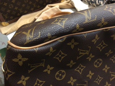 Lot 2090 - Louis Vuitton travel bag with signature monogrammed design and leather handles, together with a Louis Vuitton padlock and key, and. Versace umbrella