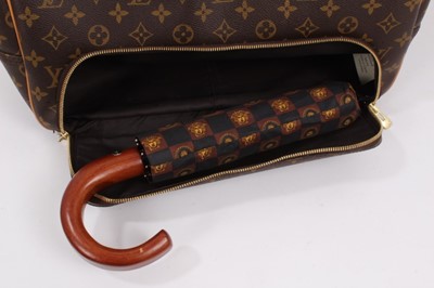 Lot 2090 - Louis Vuitton travel bag with signature monogrammed design and leather handles, together with a Louis Vuitton padlock and key, and. Versace umbrella