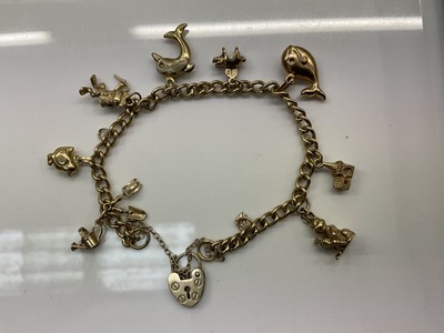 Lot 816 - 9ct gold charm bracelet with eight gold charms