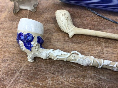 Lot 91 - Small Nailsea glass rolling pin, tiny glass seated dog and two 19th century clay pipes