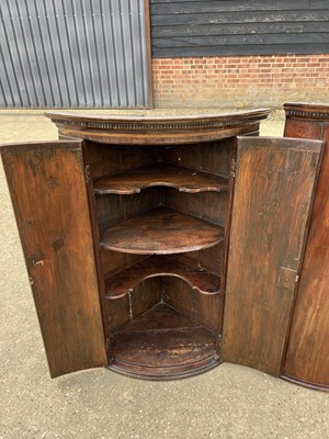 Lot 58 - Two George III mahogany bowfront corner cupboards